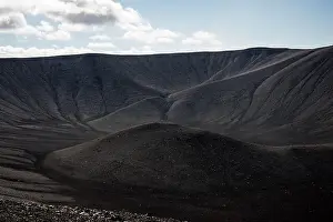 Majestic view of an erupted volcano crater with black sand and scenic landscape in the background