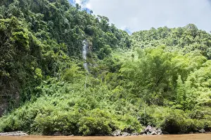 Environmental Conservation Prints: Majestic waterfall flowing in the tropical rainforest landscape under a cloudy sky in Suva