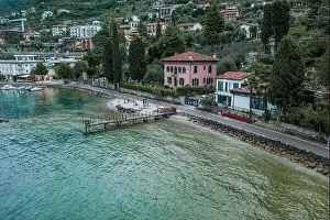 Lake Garda Prints: Malcesine, Italy - August 7, 2019: Tourists walk on lakeside of Lake Garda