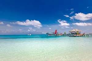 Maldives background concept. Traditional boat Dhoni, wooden jetty tropical island and beach. Summer vacation and luxury travel concept, seaplane