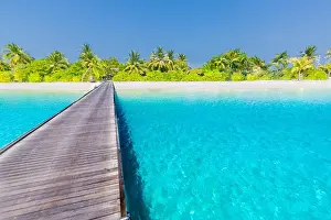 Maldives island beach panorama. Palm trees and beach bar and long wooden pier pathway. Tropical vacation and summer holiday background concept