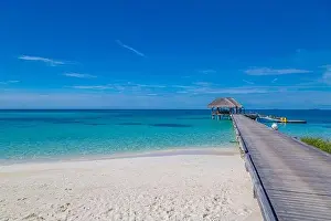 Maldives island beach. Tropical landscape of summer scenery, sea sand sky over jetty pier. Luxury travel vacation destination. Exotic beach landscape