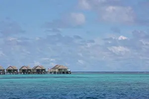 Maldives island, luxury water villas resort and wooden pier. Beautiful sky and clouds and beach background for summer vacation holiday and travel