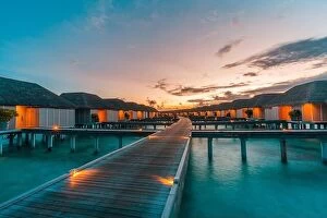 Images Dated 26th May 2019: Maldives island and water villas. Island in ocean, overwater villas at the time sunset with led