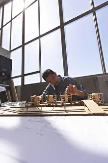 Architectural Model Prints: Male architect working on architectural model at desk in a modern office