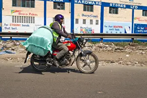 A male boda boda motorbike rider carrying a large bag on the back of his motorcycle, Nairobi, Kenya, East Africa