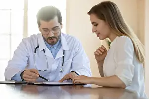 Examine Prints: Serious male family doctor discussing medical insurance agreement with patient