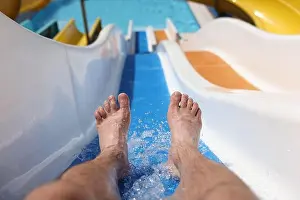 Waterpark Prints: Male feet with splashing water on slide in water park