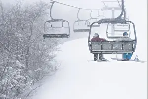 Grown Up Prints: Two male free skiers sitting in the chairlift among snowy trees in Limone Piemonte, Italy