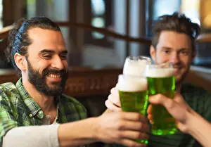 male friends drinking green beer at bar or pub