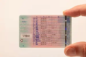 Id Card Prints: Male hand holding EU card driving license with overview of driver's license classes