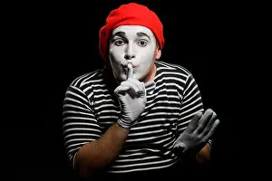 Clown Prints: Male mime showing silence sign. Actor, dressed in striped t-shirt and red hat