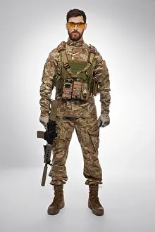 Serviceman Prints: Serious male soldier with rifle in hand