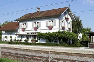 Baskets Prints: Mammern Railway Station in Switzerland with pretty flower filled window boxes