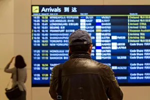 Transports Prints: A man in a baseball caps looks at the Arrivals Board in Haneda International Airport