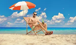 Blue Bottle Prints: Man at the beach sitting under umbrella with a bottle of cold beer