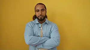 Calmness Prints: Man with beard and glasses standing with arms crossed over yellow background