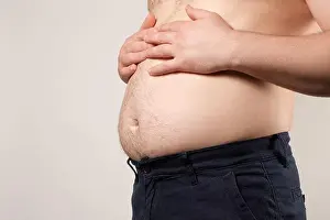 Weight Loss Prints: A man with a big sagging stomach, the concept of excess weight in men, a place for text