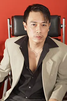 Chinese Ethnicity Prints: Man in black shirt and beige jacket, sitting on chair, looking at camera