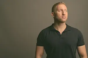 Polo Prints: Man with blond hair wearing black polo shirt against gray background
