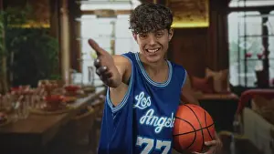 Grip Prints: Man in blue los angeles jersey 77 reaching out with hand and holding a basketball