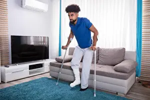 Injured Prints: Man With Broken Leg Using Crutches For Walking On Blue Carpet