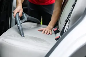 Cleaner Prints: man cleaning car interior alcantara seats with vacuum cleaner