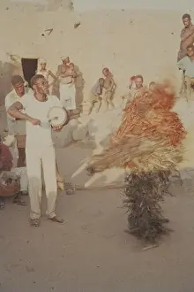 A man in costume dances to the music of a drummer in the village square of Koro. [automated translation]