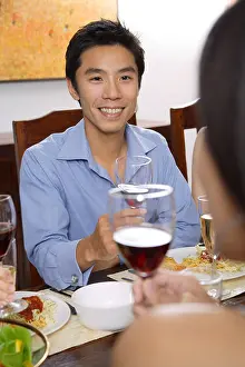 Chinese Ethnicity Prints: Man at dinner table, holding wine glasses, facing another person