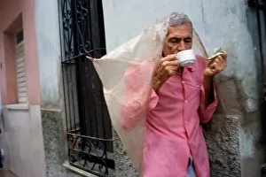 Sipping Prints: Man drinking coffee in the street on a drizzly day in Santa Clara Cuba