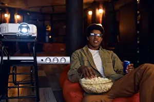 Lazy Prints: Man enjoy watching film using video projector