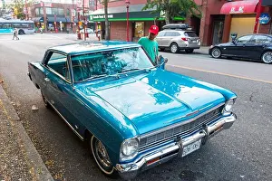 Chevy Prints: man gets into vintage blue 1960s Chevrolet nova in a street in Vancouver Canada