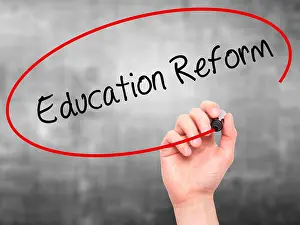 Man Hand writing Education Reform with black marker on visual screen