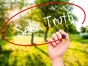 Examine Prints: Man Hand writing Seek Truth with black marker on visual screen