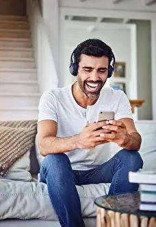 Mobile App Prints: Man, headphones and laughing with phone on couch for funny video