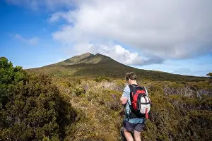 Wide Shot Prints: man hiking up a mountain with a backpack, alpine wilderness