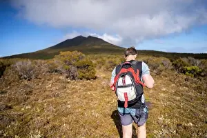 Wide Shot Prints: man hiking up a mountain with a backpack, alpine wilderness