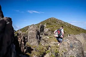 Wide Shot Prints: man hiking up a mountain with a backpack, alpine wilderness