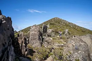 Wide Shot Prints: man hiking up a mountain with a backpack, alpine wilderness