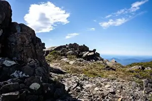 Wide Shot Prints: man hiking up a mountain with a backpack, alpine wilderness