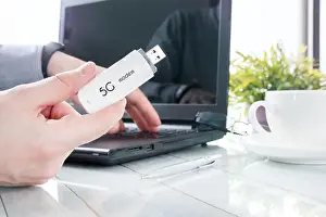 Mobile Network Prints: Man is holding modern 5G modem over office background