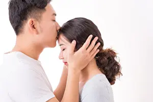 Closed Eyes Prints: A man kissing his woman's head with love and affection