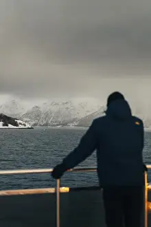 Brim Prints: Man looking at snowy Lyngen Alps on overcast arctic day, northern Norway