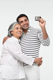 25 29 Years Prints: Man with his mother taking picture of themselves with a digital camera