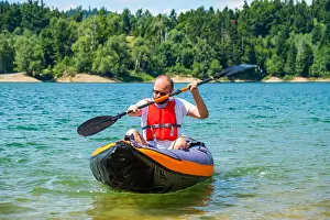 Kayaking Prints: Man paddling in inflatable kayak on lake Lokve