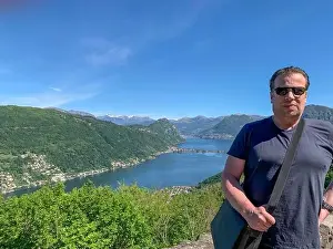 San Salvatore Prints: Man and Panoramic View over Lugano with Alpine Lake and Mountain in a Sunny Day in Ticino