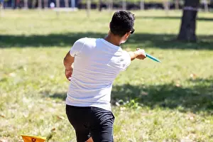 Throw Prints: Man playing flying disc golf sport game in the park