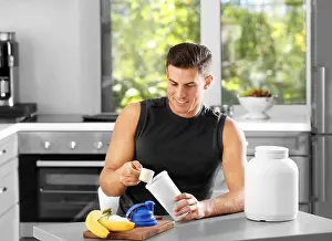 Bodybuilding Prints: Man preparing protein shake in kitchen