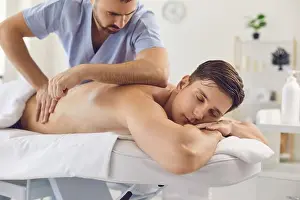 Massaging Prints: Man professional masseur in uniform making medical massage of back for relaxing man