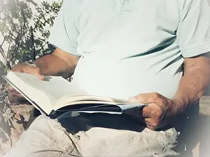 Midsection Prints: Man reading a book outdoors